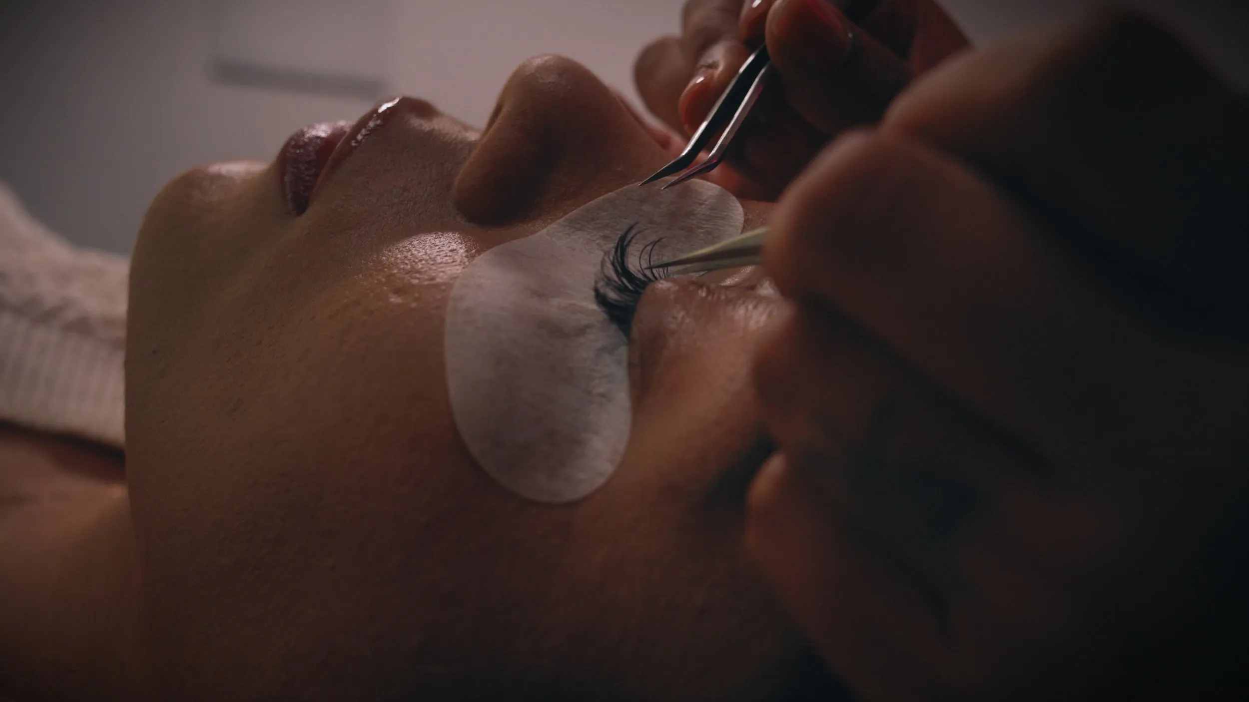 Macro close-up of eyelash extensions being applied to a client.